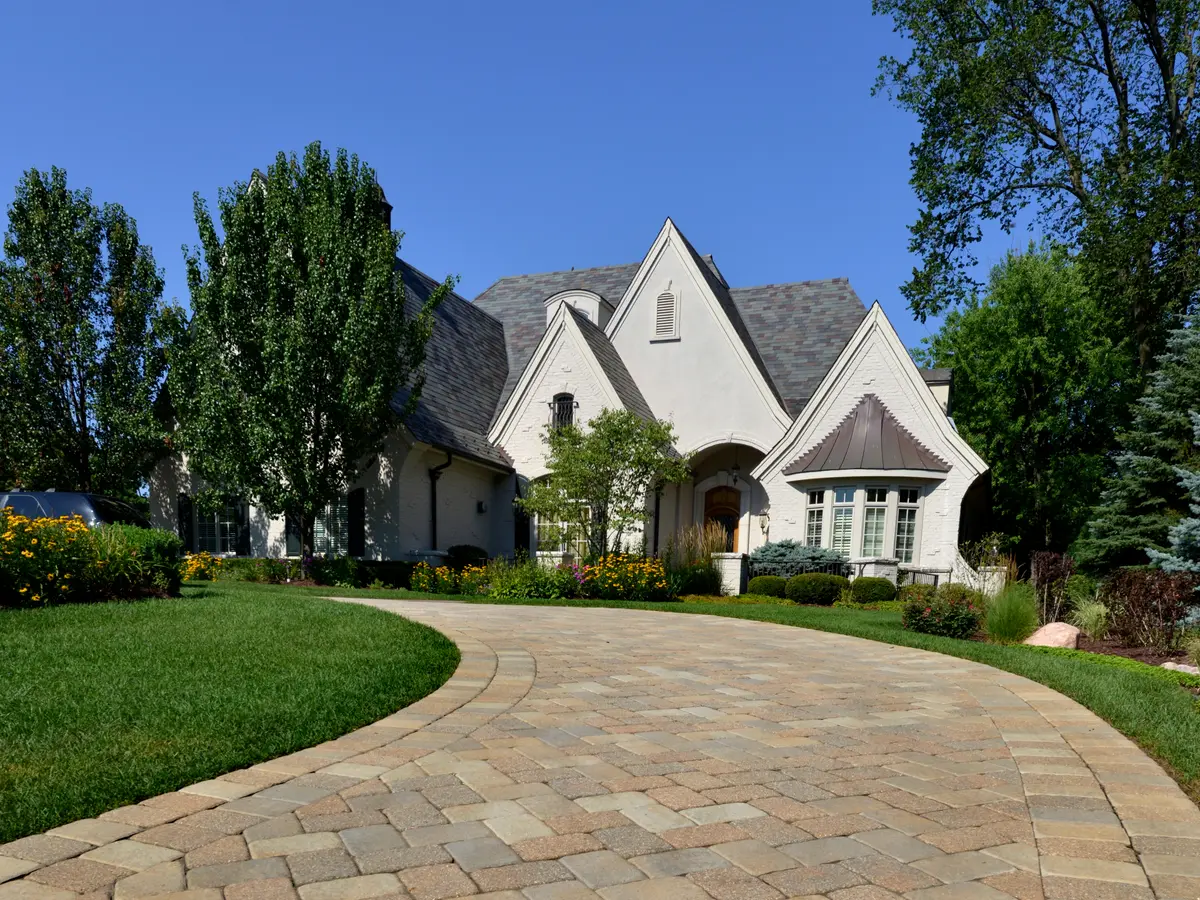 Curved paver driveway leading to a house