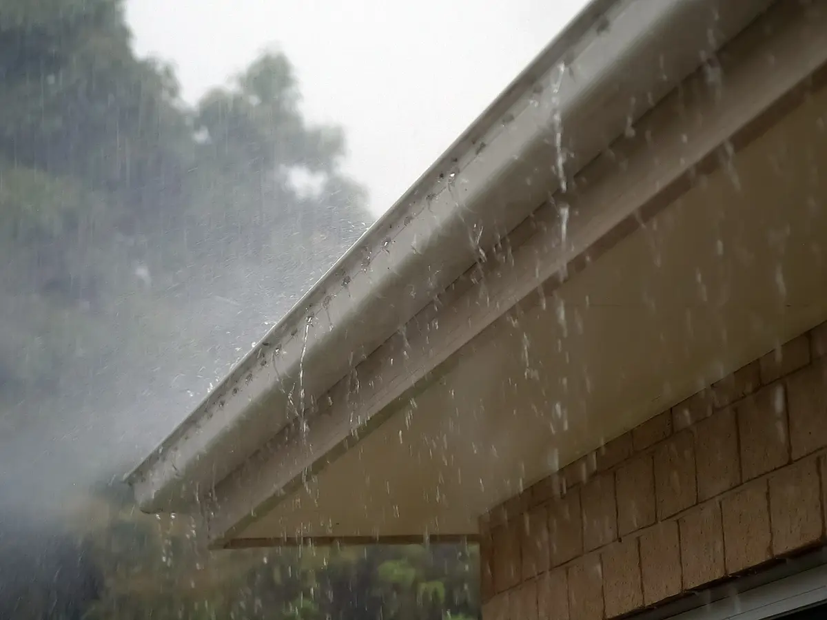 Rain pouring over the edge of an eavestrough