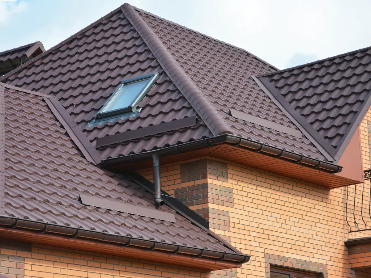 Brown concrete tile roof with hips, valleys and a roof window