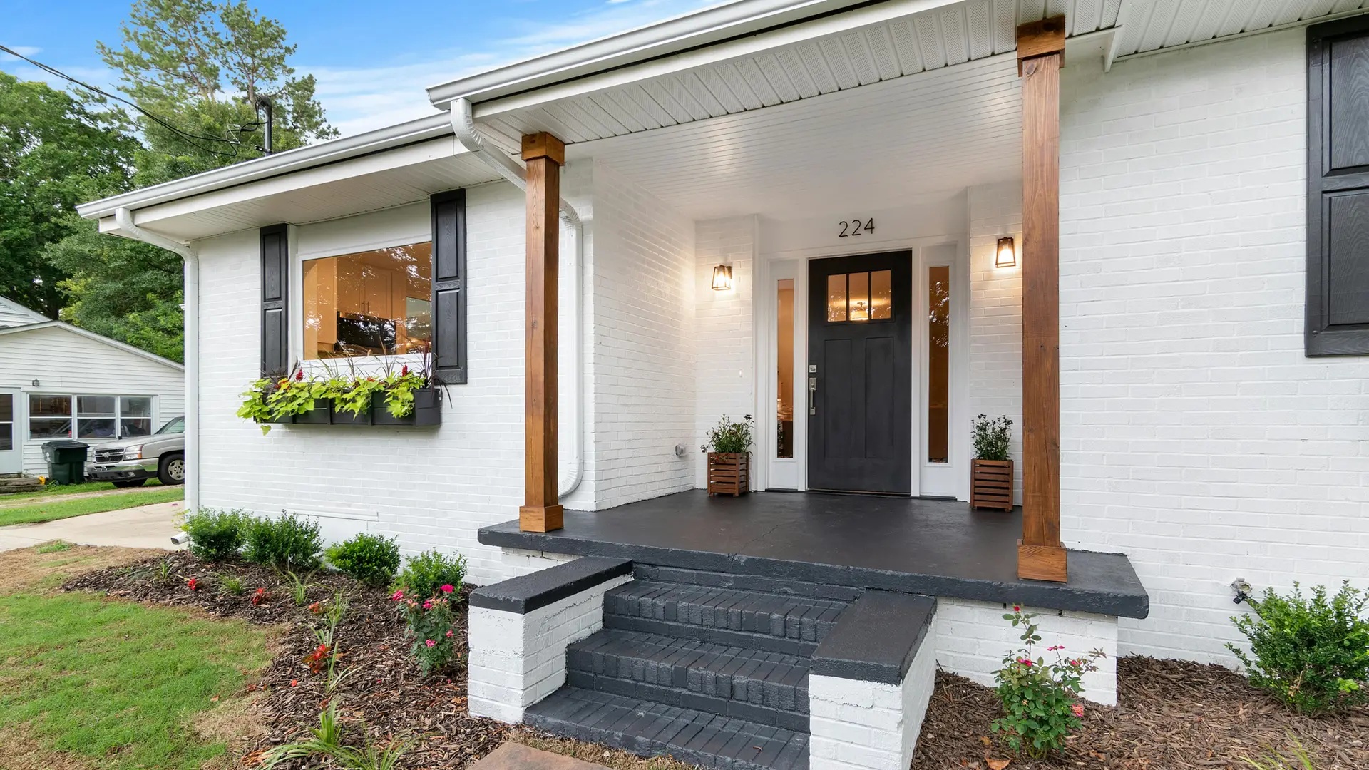 Painted brick house with a covered porch and new front steps