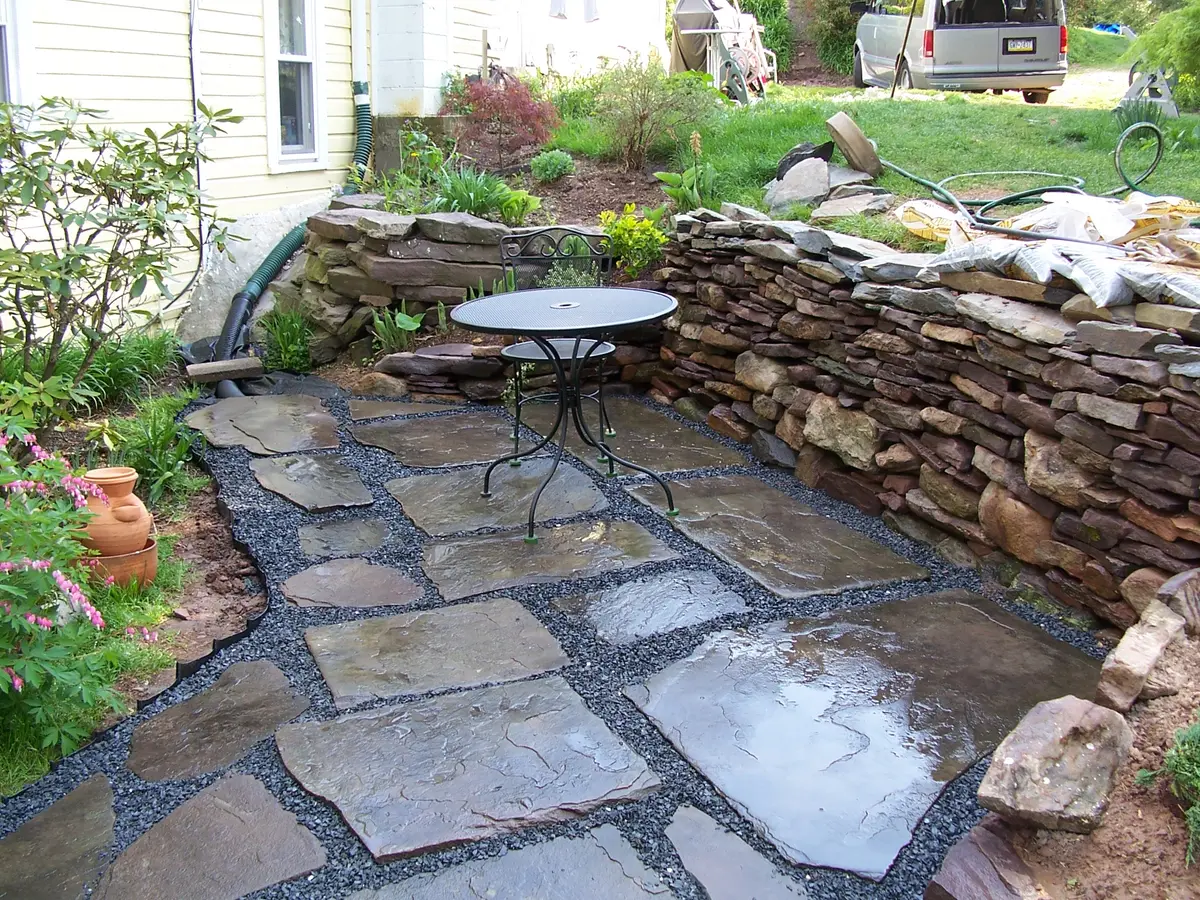 Flagstone patio with a dry stone wall and a small table