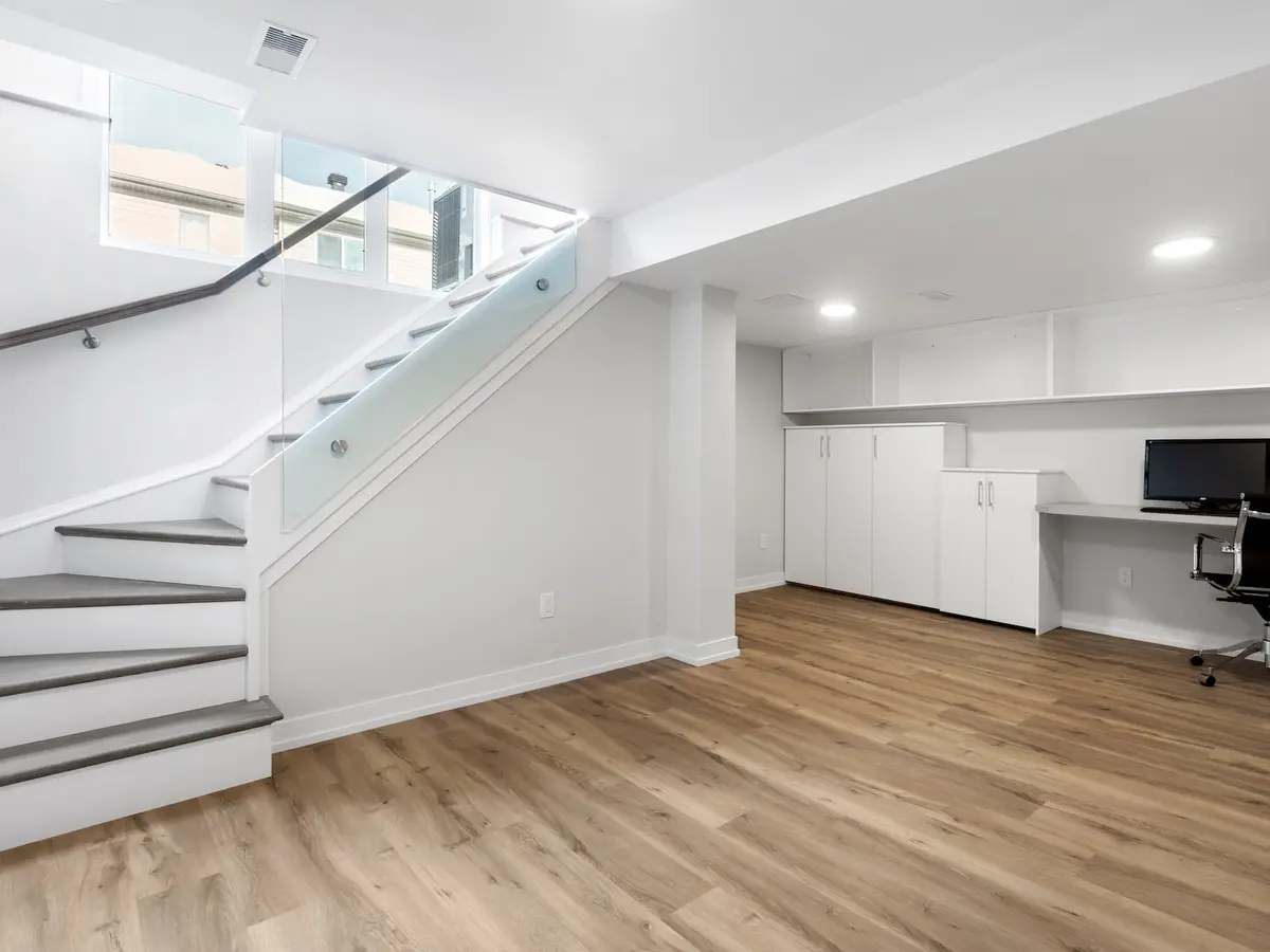 Dry finished basement with a staircase and a home office