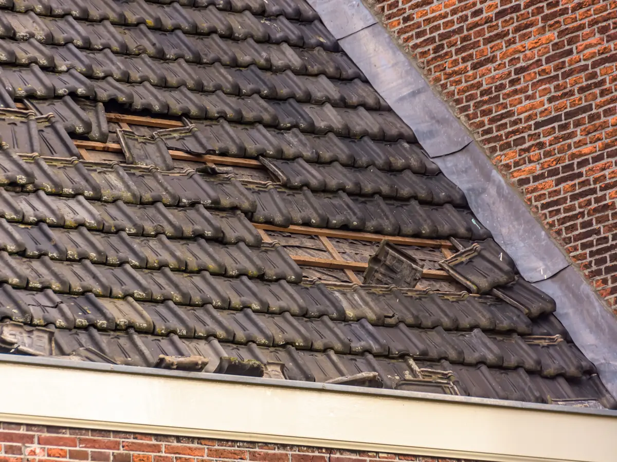 Roof with broken and missing tiles after a storm