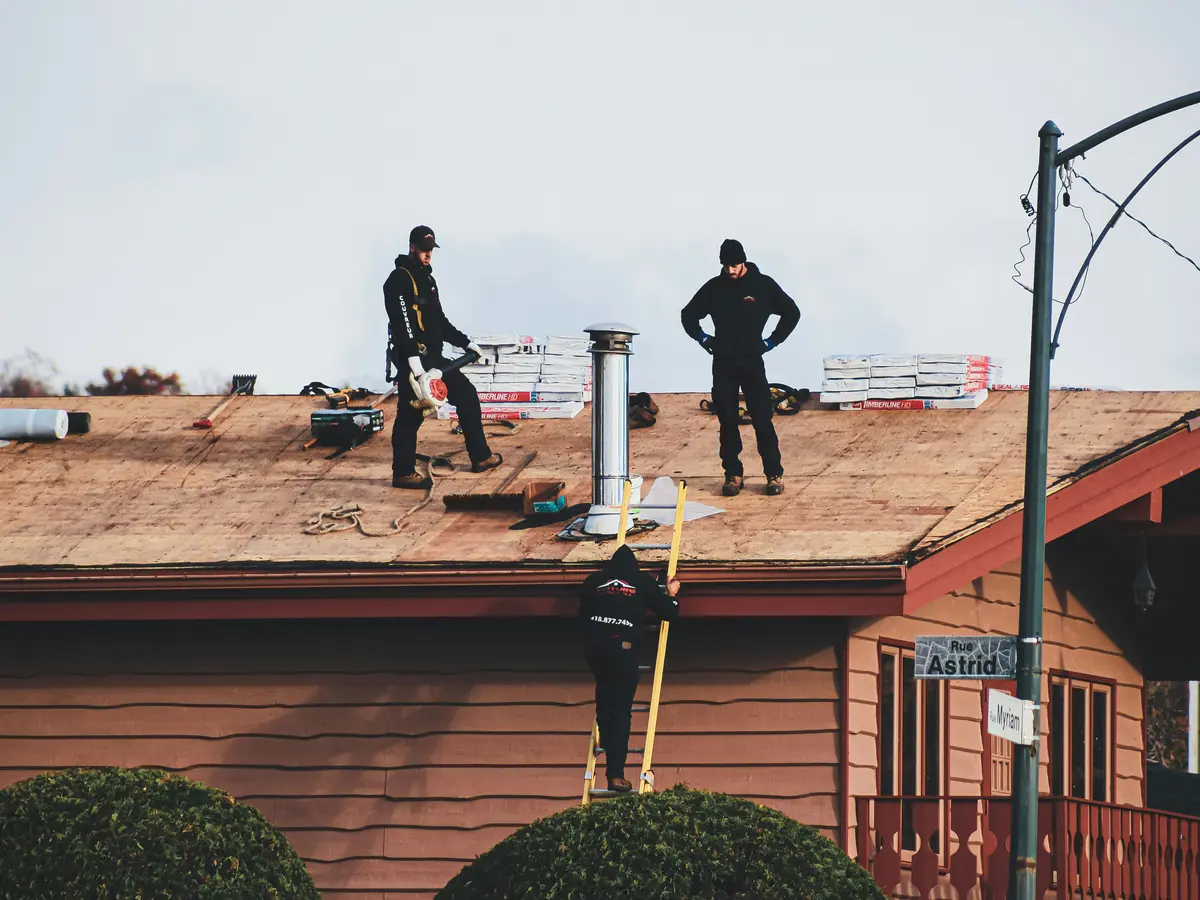Roofers stripping an old roof back to the deck on a timber house