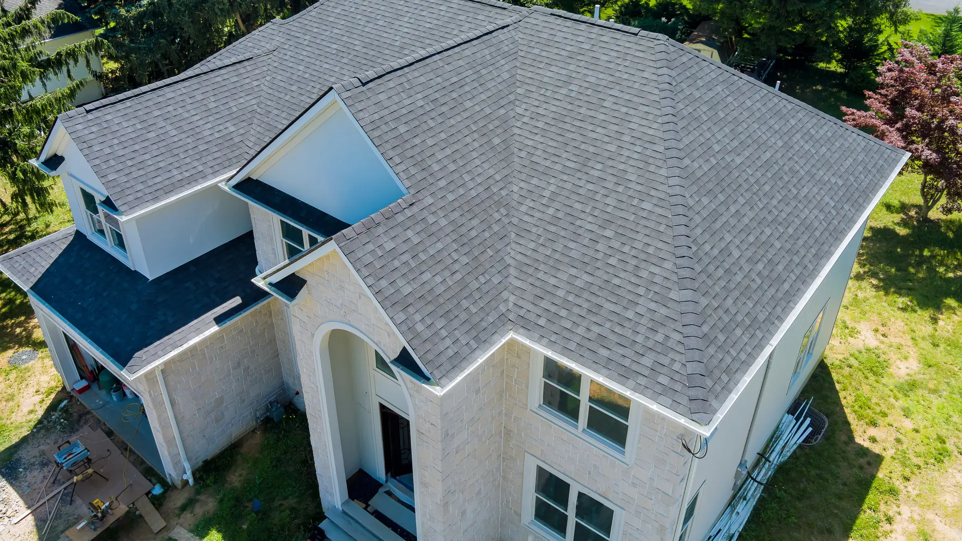 Aerial view of a detached house with a grey asphalt shingle roof
